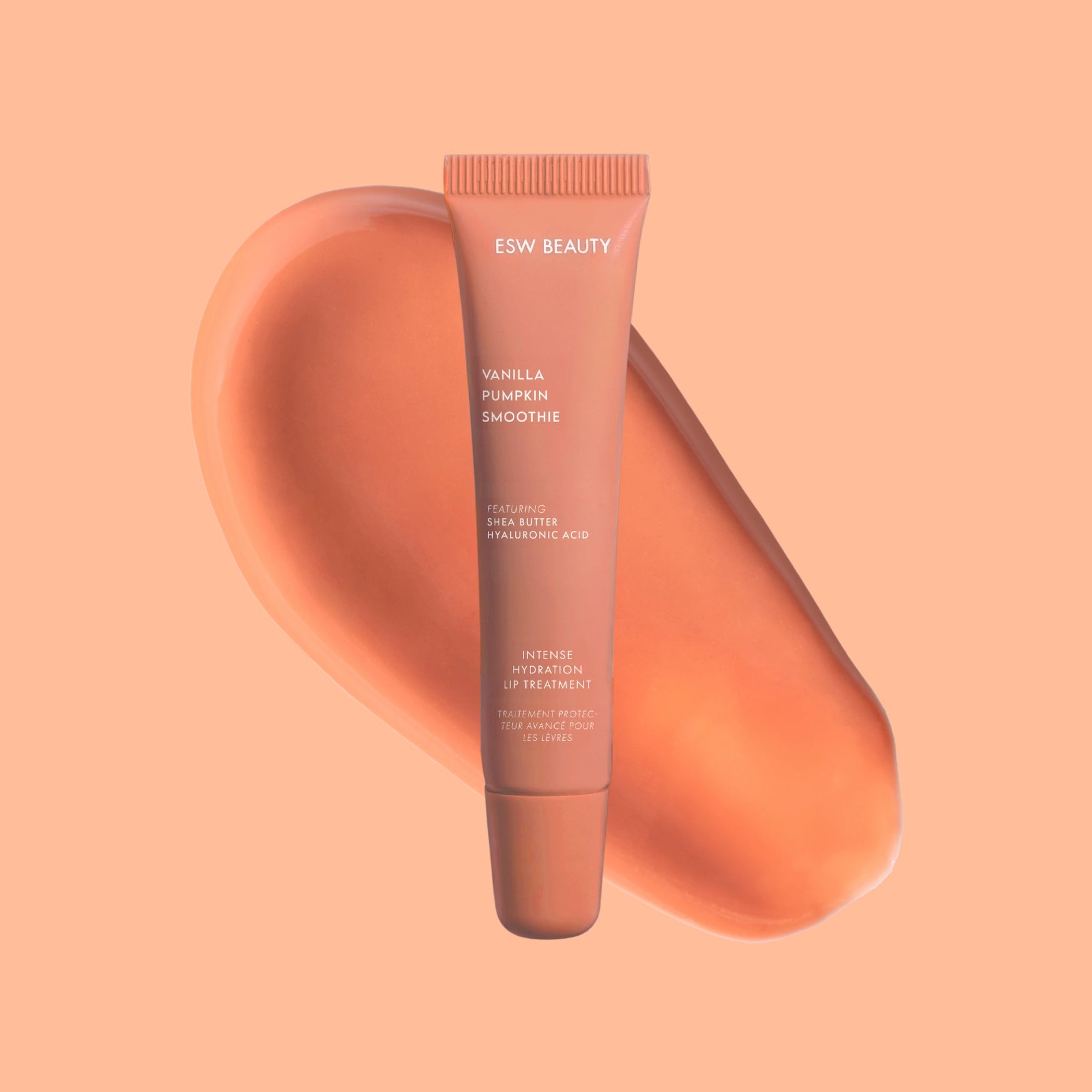 Tube of ESW Beauty lip balm on a peach background