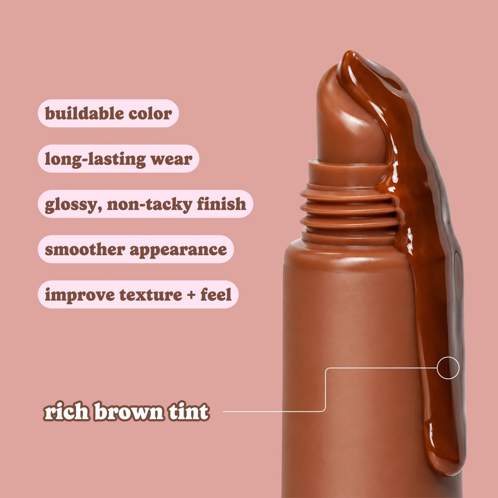 A close-up of a brown cosmetic tube with glossy brown product dripping from the top, set against a dusty pink background. White text on the left lists benefits such as buildable color, long-lasting wear, glossy non-tacky finish, smoother appearance, and rich brown tint.