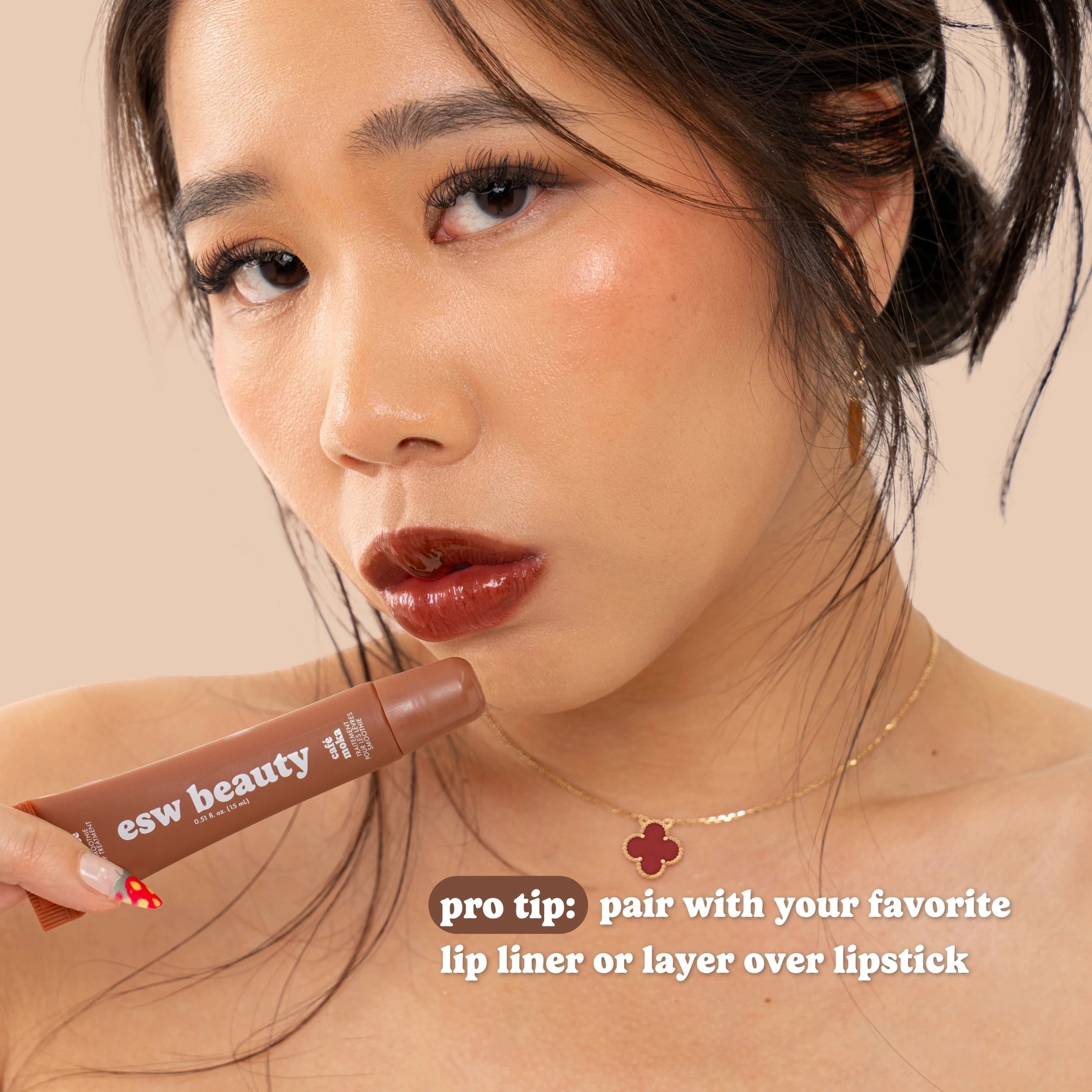 Woman with brown lipstick holding a lip product, with text on a beige background