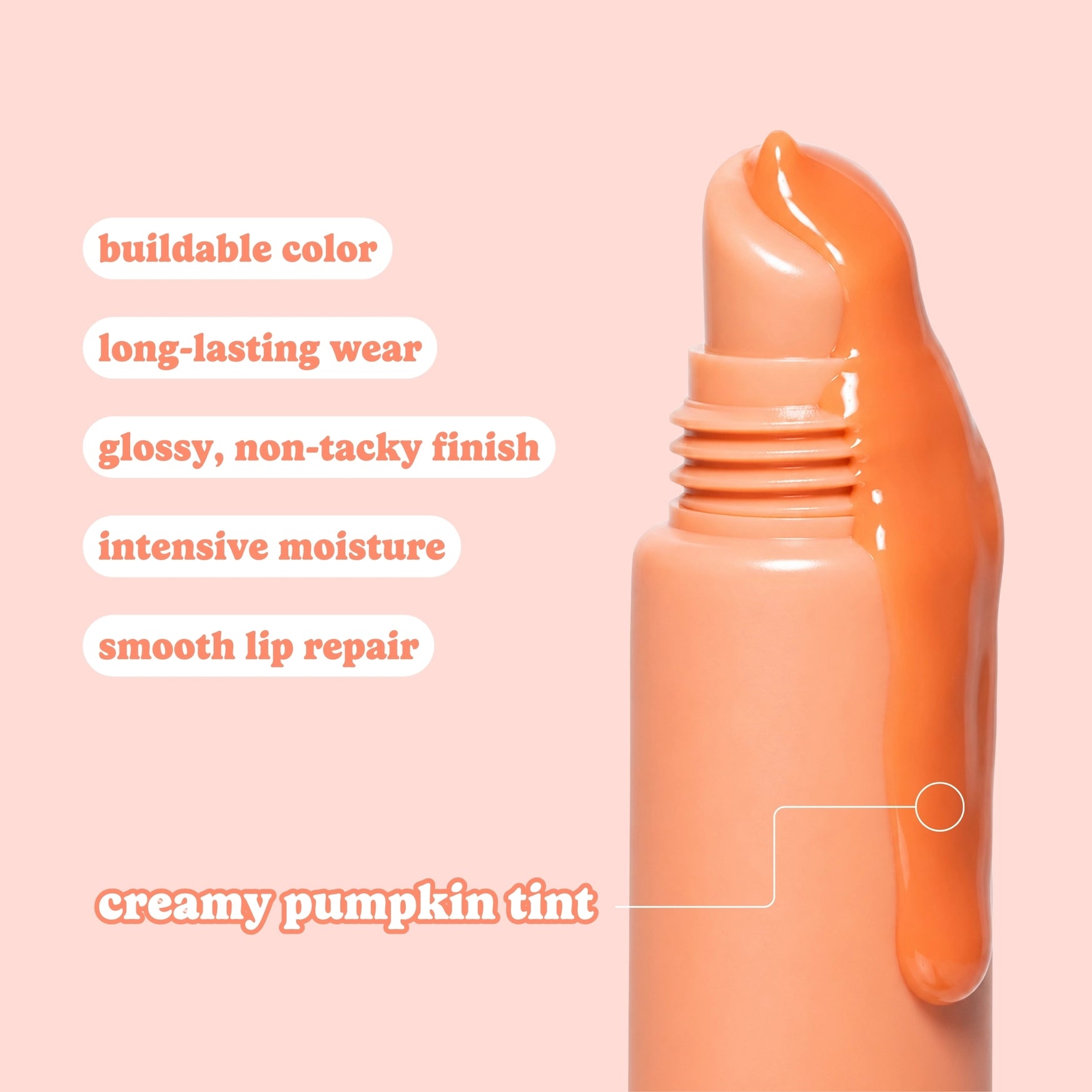 An orange cosmetic tube with a glossy, dripping applicator tip on a solid pale pink background, accompanied by text describing the creamy pumpkin tint and product benefits.