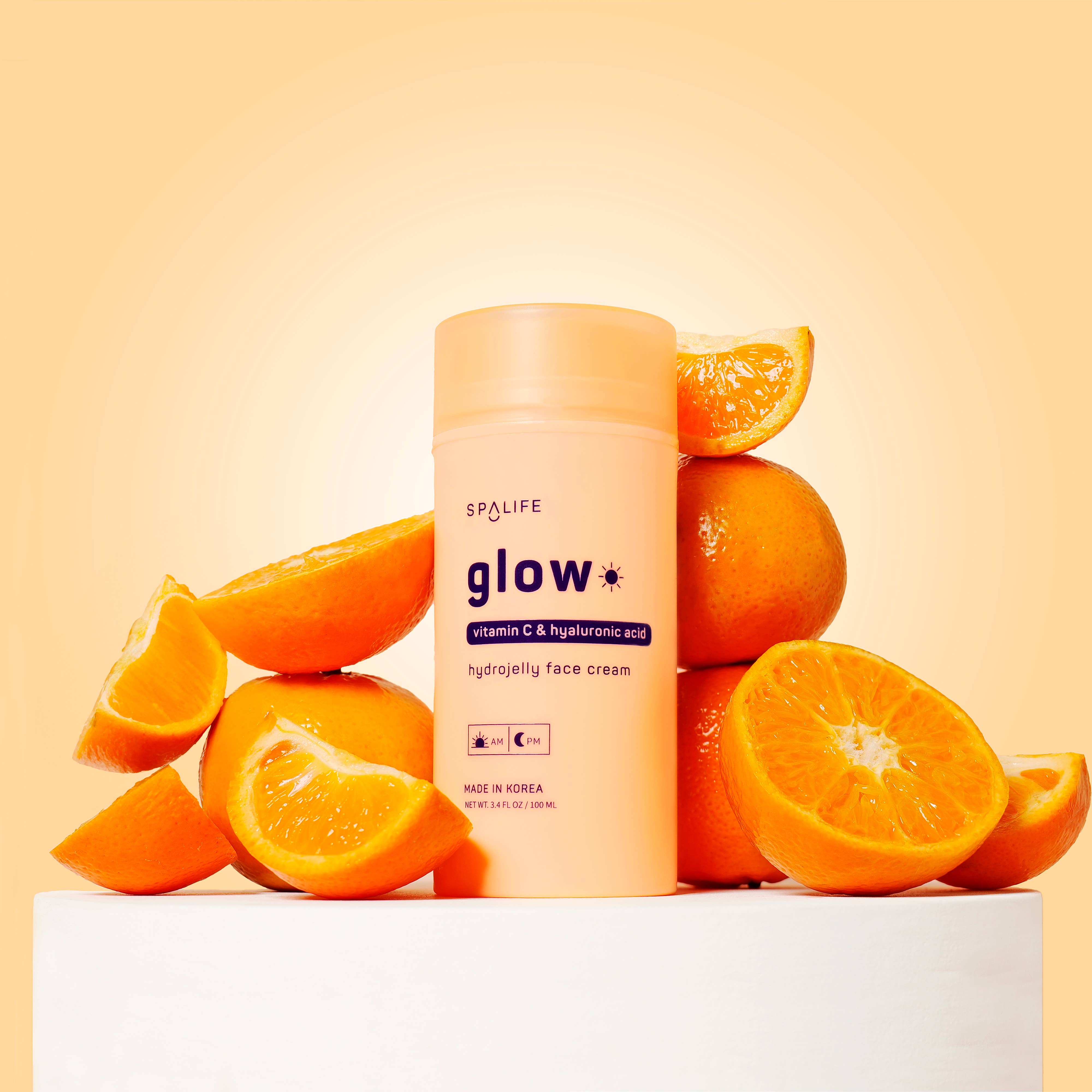 Spalife glow face cream surrounded by oranges on a yellow background