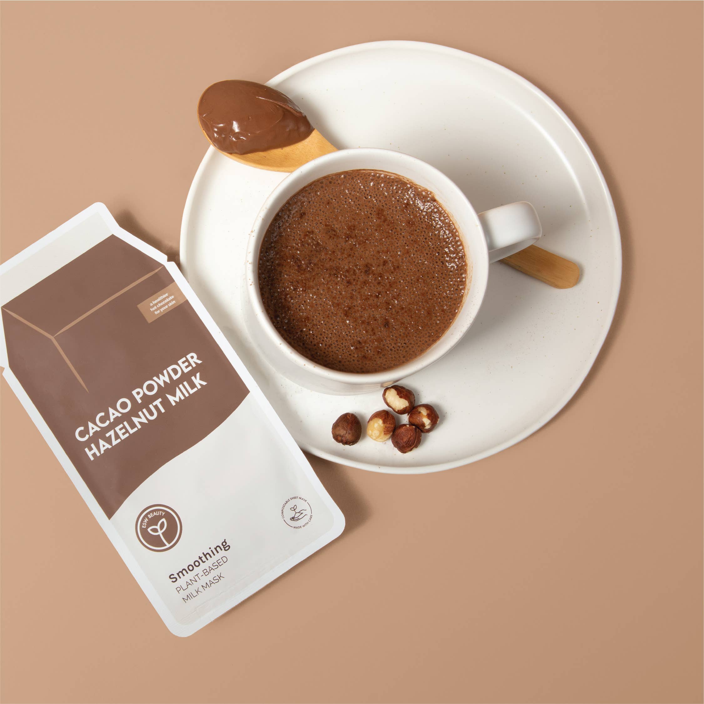 Cacao powder hazelnut milk packaging with a cup of hot chocolate on a beige background
