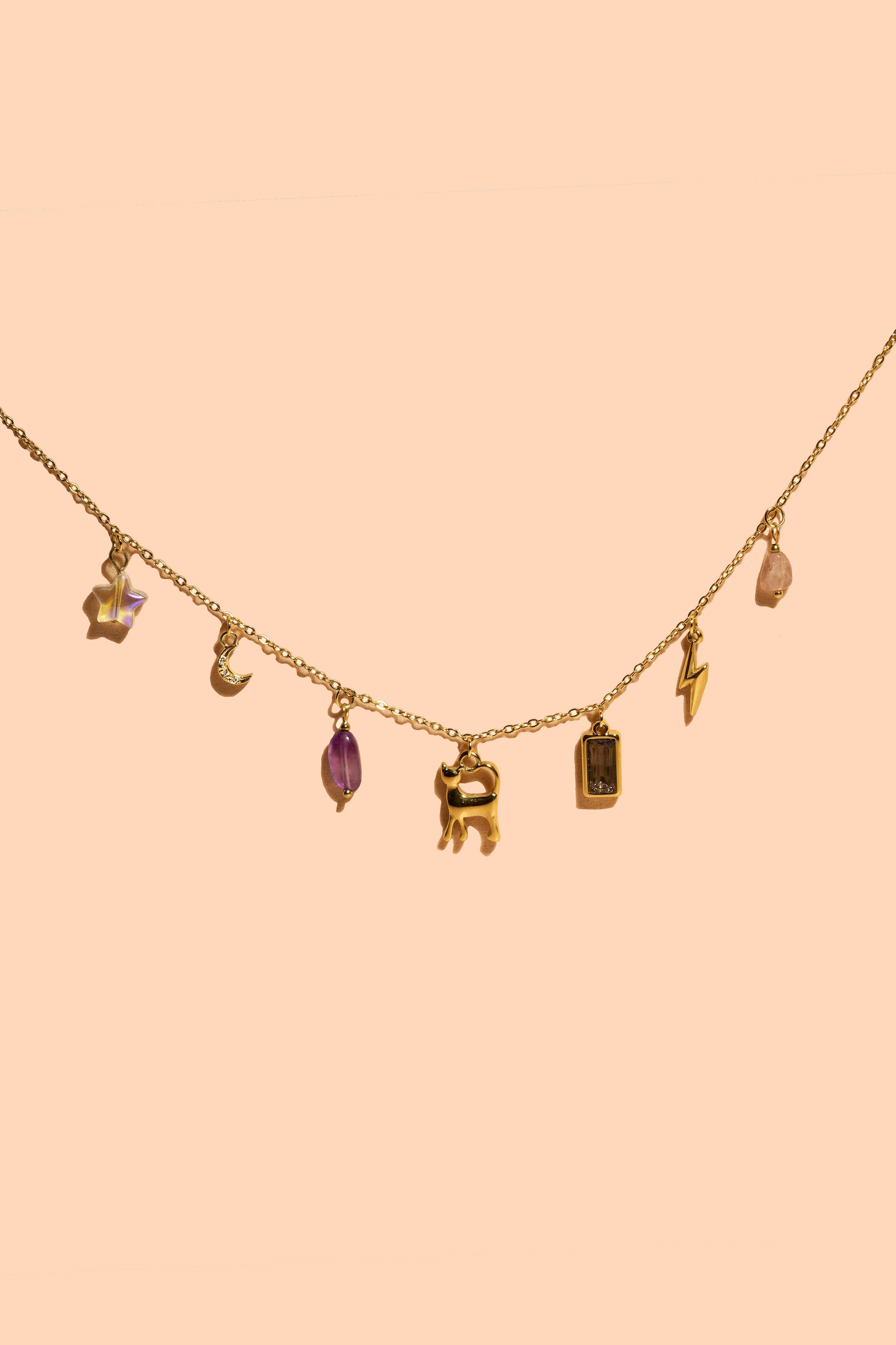 Necklace with various charms on a peach background