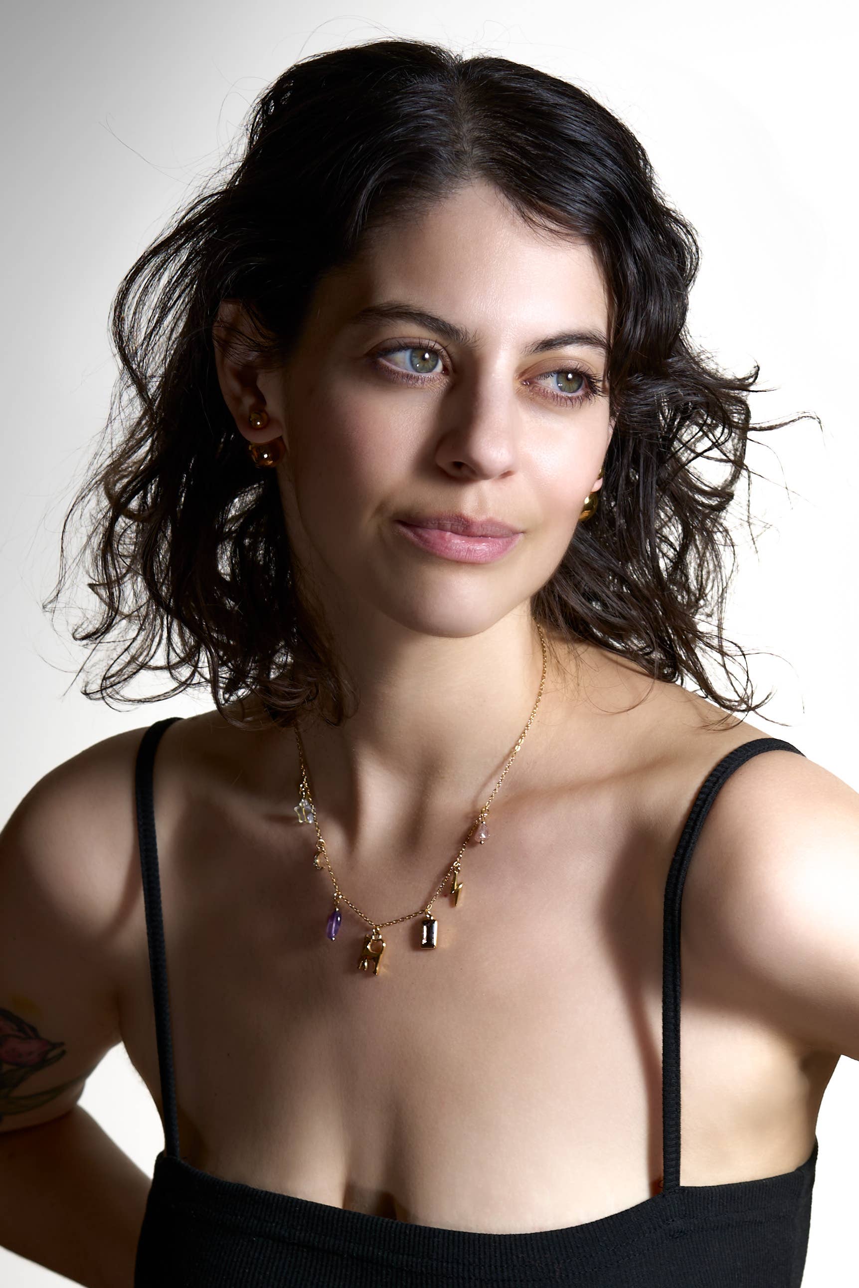 Woman wearing a black top with thin straps against a white background