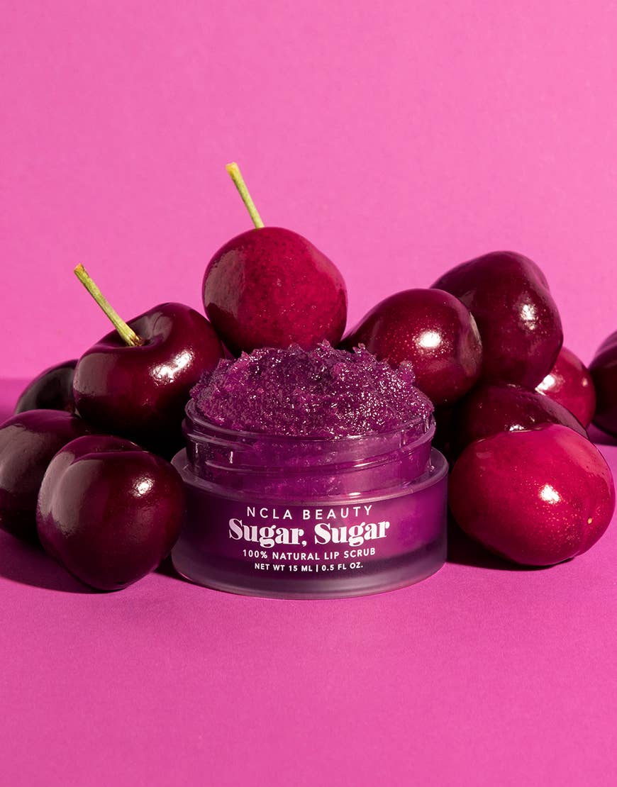 Purple lip scrub jar with cherries on a pink background