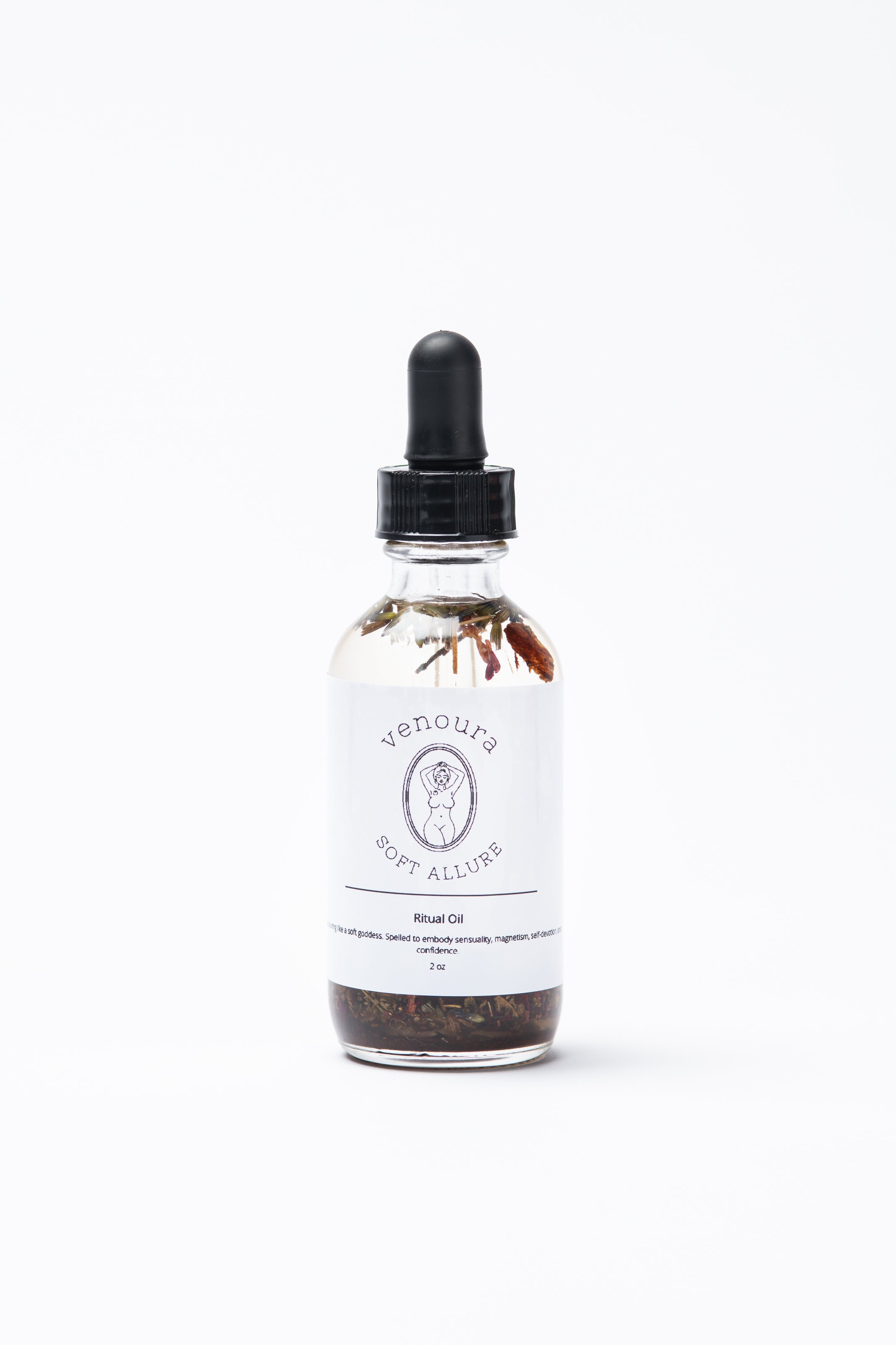 A clear glass dropper bottle of Venoura Soft Allure Ritual Body Oil with a black rubber dropper cap and a white label, set against a plain white background. Used for spellwork and skincare.