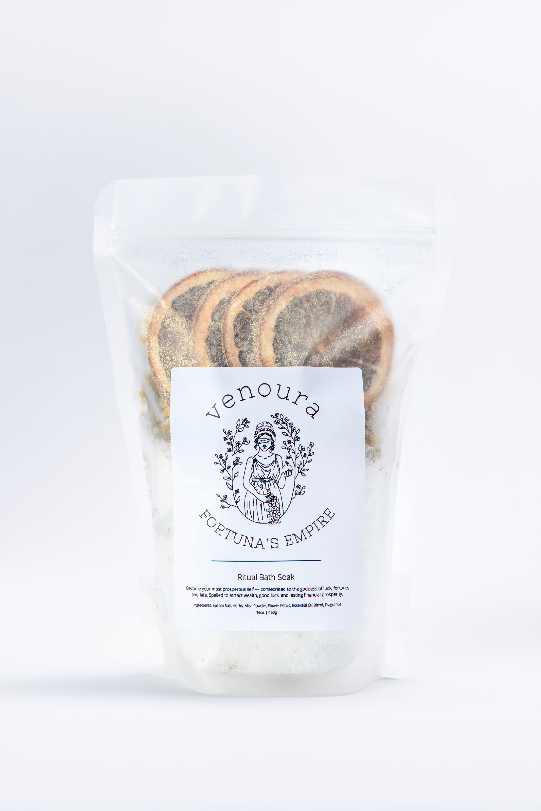 A clear stand-up pouch containing white bath soak powder with visible dried botanical slices, labeled Venoura Foetuna's Empyre Ricol Bath Soak, on a clean white background.