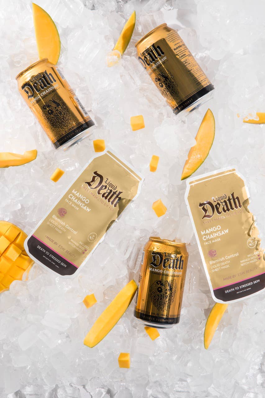 Five cans of 'Death by Mango' Chambord on a white background with mango slices.