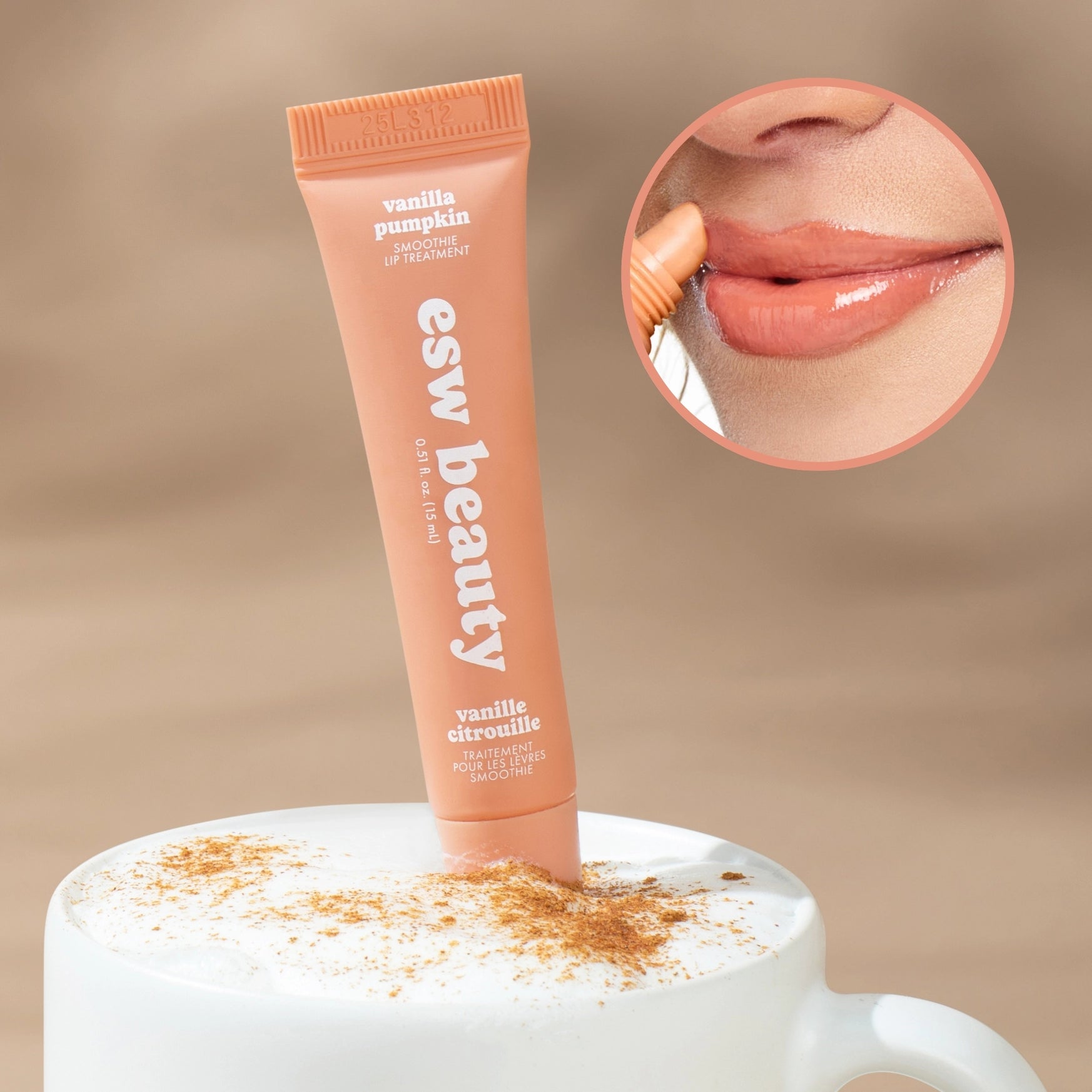 A tube of esw beauty lip gloss in vanilla pumpkin stands upright in a white cup with whipped cream and cinnamon dusting. An oval inset shows a close-up of glossy lips wearing the product.