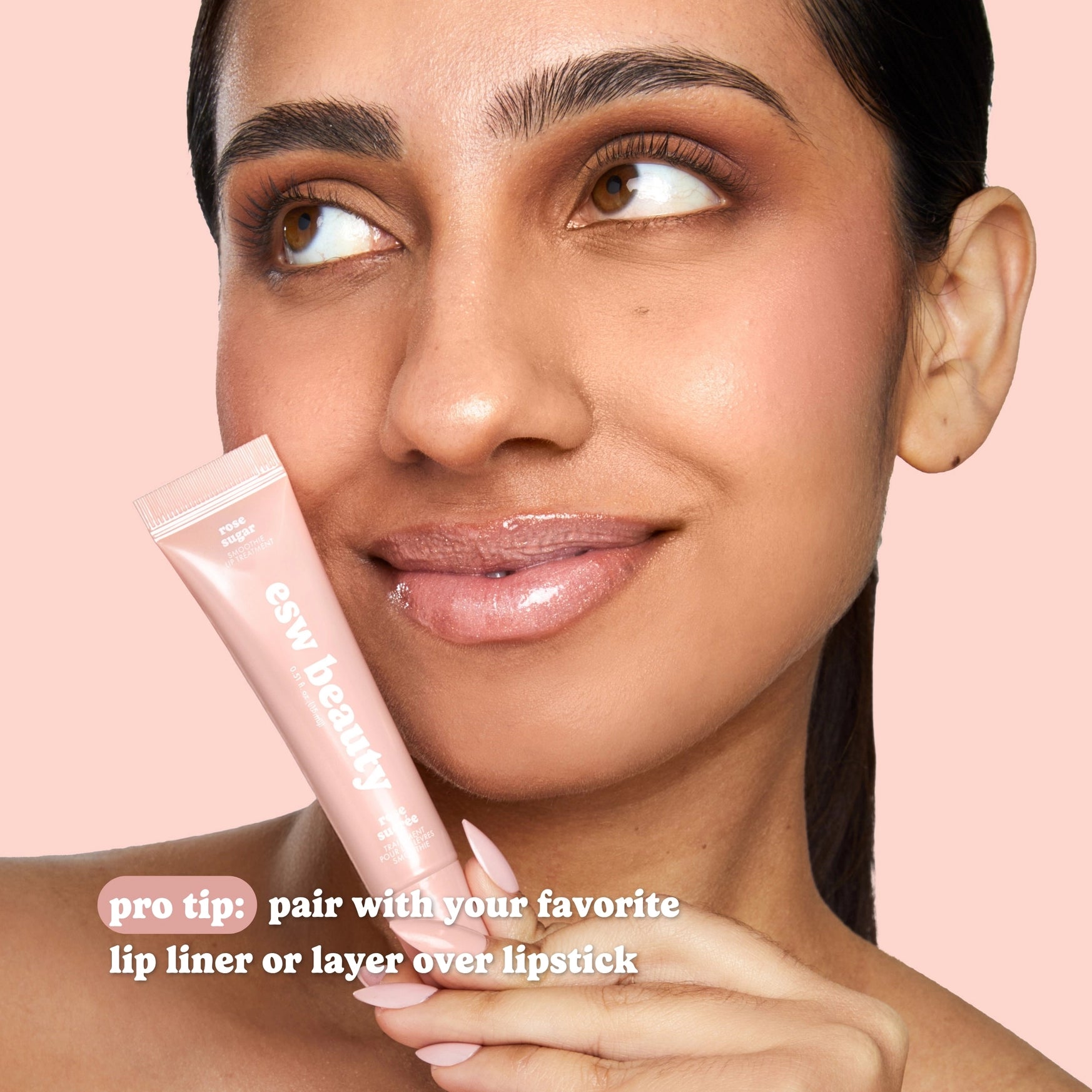 Woman holding a pink lip balm with text on a pink background
